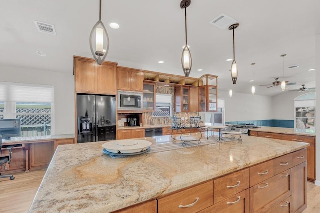 815 Clarence Bohls Ln, Pflugerville, TX 78660 - kitchen featuring black appliances, ceiling fan, light stone counters, glass insert cabinets, and brown cabinets