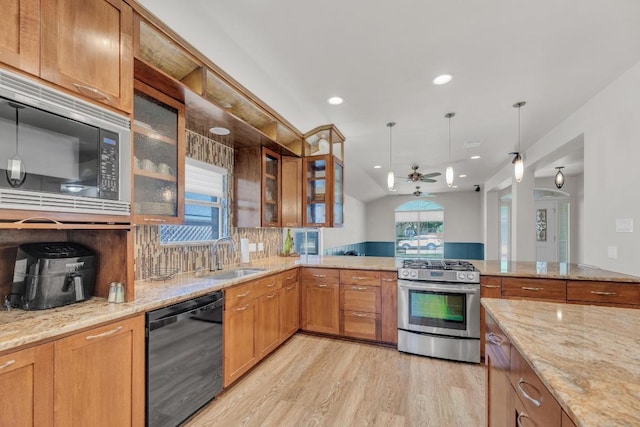 815 Clarence Bohls Ln, Pflugerville, TX 78660 - kitchen with dishwasher, stainless steel gas stove, ceiling fan, light stone counters, and light wood-type flooring