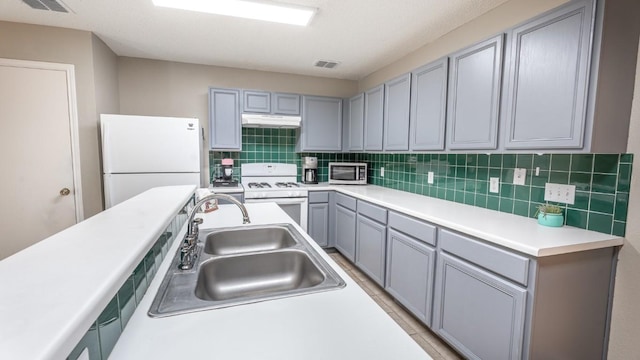 8086 Thaxton Rd, Austin, TX 78747 - kitchen featuring white appliances, under cabinet range hood, gray cabinets, decorative backsplash, and light countertops