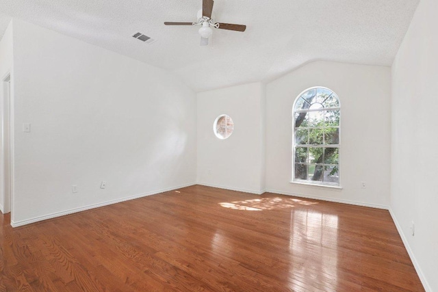 13302 Black Canyon Dr, Austin, TX 78729 - empty room with ceiling fan, wood finished floors, lofted ceiling, and a textured ceiling