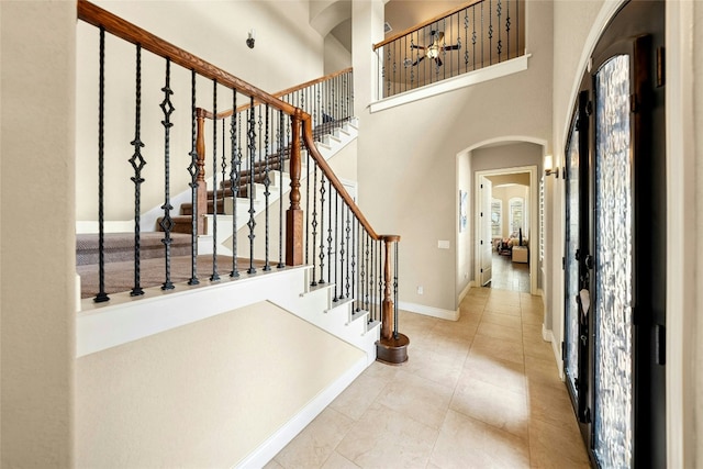 1073 Las Brisas Dr, Canyon Lake, TX 78133 - foyer entrance with arched walkways, a high ceiling, tile patterned floors, and stairway