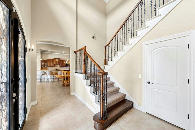 1073 Las Brisas Dr, Canyon Lake, TX 78133 - foyer featuring arched walkways, light tile patterned floors, stairway, and a towering ceiling