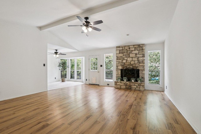 1613 J J Seabrook Dr, Austin, TX 78721 - unfurnished living room featuring a ceiling fan, wood finished floors, healthy amount of natural light, and a stone fireplace