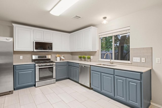 2716 Cradlerock Ter, Austin, TX 78748 - kitchen featuring stainless steel appliances, light countertops, backsplash, white cabinetry, and blue cabinets