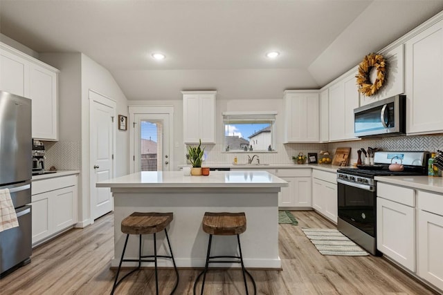 209 Lambert St, Leander, TX 78641 - kitchen with stainless steel appliances, light wood-style flooring, decorative backsplash, white cabinets, and recessed lighting