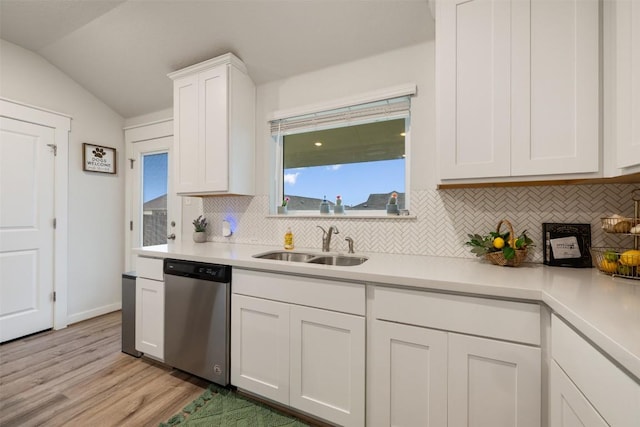 209 Lambert St, Leander, TX 78641 - kitchen with stainless steel dishwasher, backsplash, light countertops, light wood-style flooring, and vaulted ceiling