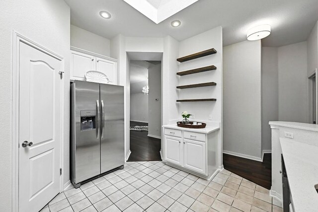 6428 Clay Allison Pass, Austin, TX 78749 - kitchen featuring stainless steel refrigerator with ice dispenser, light countertops, white cabinetry, open shelves, and light tile patterned floors