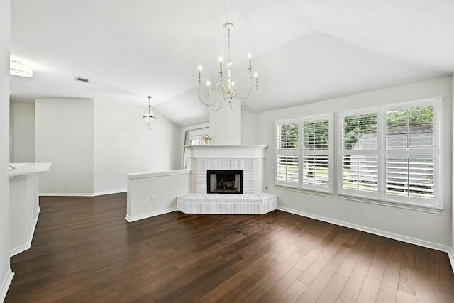 6428 Clay Allison Pass, Austin, TX 78749 - unfurnished living room with vaulted ceiling, dark wood-type flooring, a chandelier, and a brick fireplace
