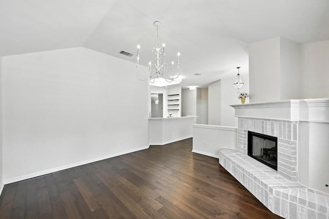 6428 Clay Allison Pass, Austin, TX 78749 - unfurnished living room featuring a chandelier, a fireplace, wood finished floors, built in shelves, and vaulted ceiling