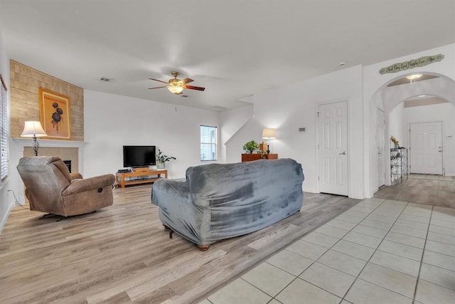 2101 Charlotte Estates Dr, Austin, TX 78744 - living area featuring ceiling fan, light wood finished floors, and arched walkways