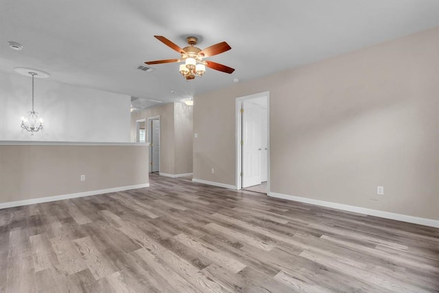 2101 Charlotte Estates Dr, Austin, TX 78744 - unfurnished room featuring a ceiling fan, wood finished floors, a smoke detector, and a chandelier