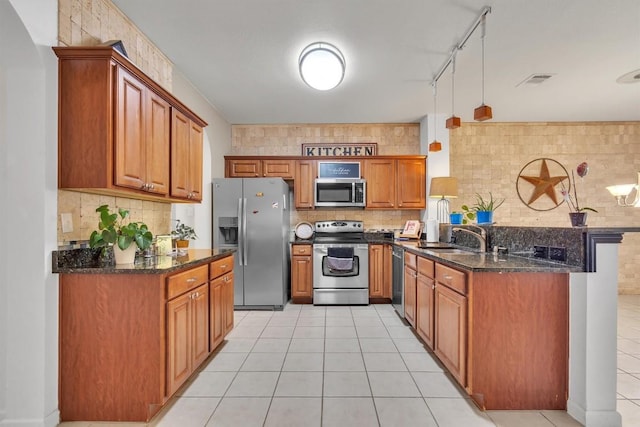 2101 Charlotte Estates Dr, Austin, TX 78744 - kitchen featuring stainless steel appliances, brown cabinets, backsplash, and a peninsula