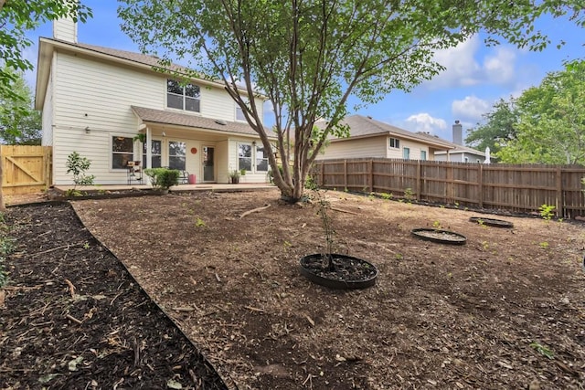 2101 Charlotte Estates Dr, Austin, TX 78744 - back of property with a chimney, a fenced backyard, and a patio