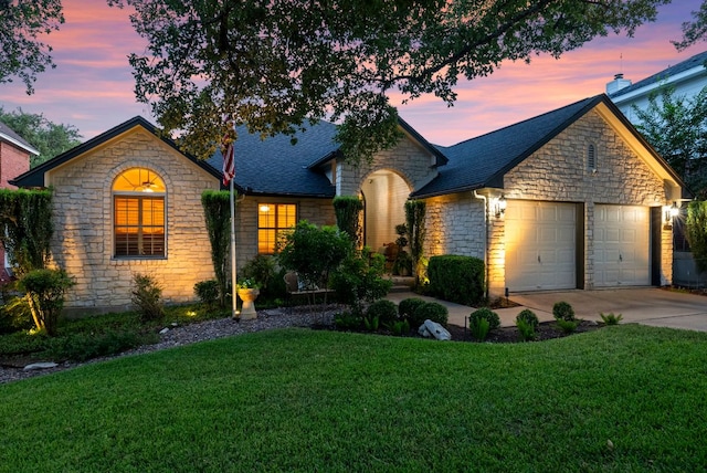 10839 Redmond Rd, Austin, TX 78739 - view of front of home with stone siding, an attached garage, concrete driveway, a yard, and roof with shingles