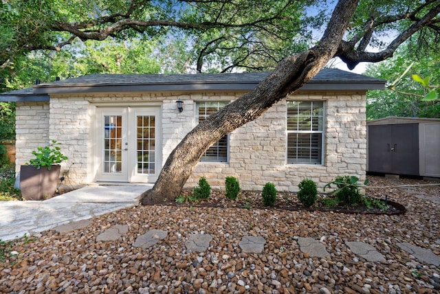 10839 Redmond Rd, Austin, TX 78739 - view of front of property with stone siding, french doors, and a storage unit