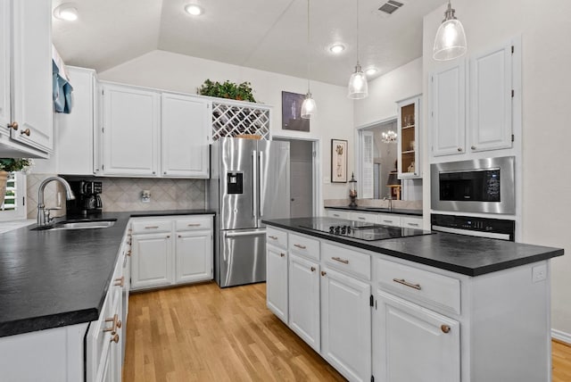 10839 Redmond Rd, Austin, TX 78739 - kitchen with stainless steel appliances, dark countertops, light wood-type flooring, backsplash, and white cabinetry