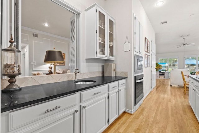 10839 Redmond Rd, Austin, TX 78739 - kitchen with appliances with stainless steel finishes, open floor plan, glass insert cabinets, light wood-type flooring, and recessed lighting