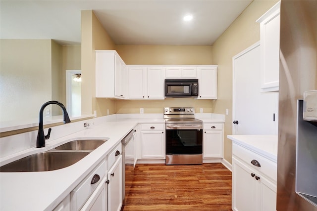 136 Holmstrom St, Hutto, TX 78634 - kitchen with appliances with stainless steel finishes, white cabinets, light wood-type flooring, and light countertops