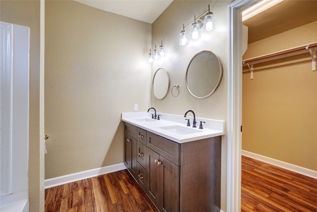 136 Holmstrom St, Hutto, TX 78634 - full bath featuring wood finished floors, double vanity, and a walk in closet