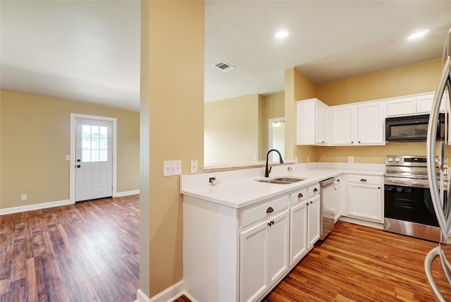 136 Holmstrom St, Hutto, TX 78634 - kitchen featuring appliances with stainless steel finishes, light wood finished floors, white cabinets, and light countertops