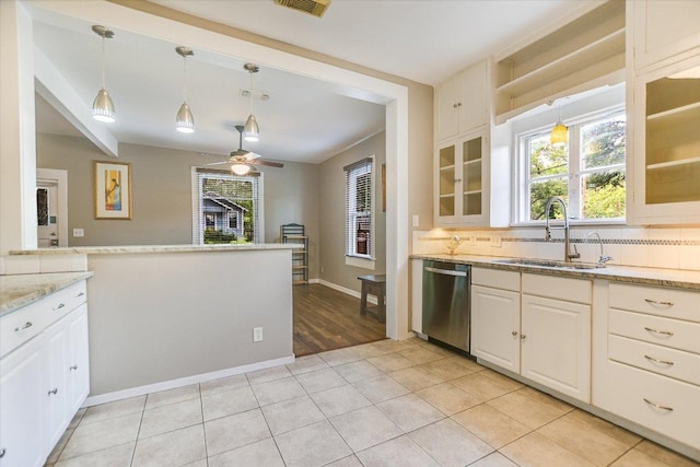 4415 Ave D Ave, Austin, TX 78751 - kitchen featuring dishwasher, backsplash, glass insert cabinets, hanging light fixtures, and light stone counters