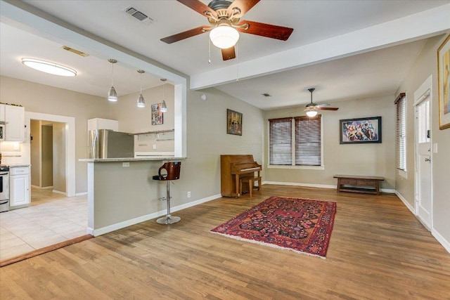 4415 Ave D Ave, Austin, TX 78751 - kitchen with a ceiling fan, appliances with stainless steel finishes, a kitchen breakfast bar, white cabinetry, and light wood finished floors