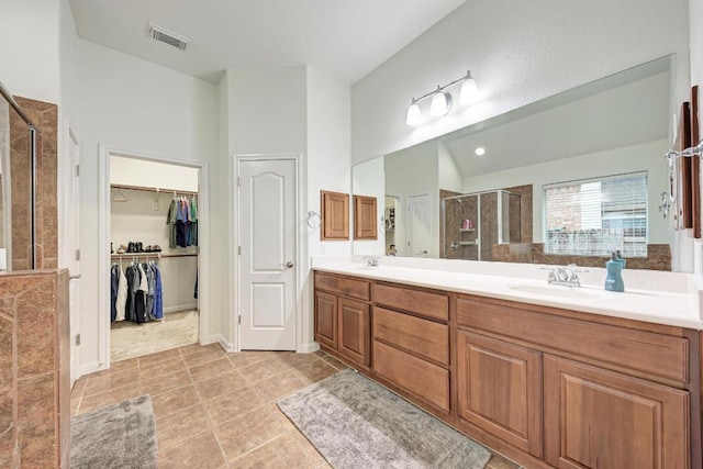 518 Victoria Dr, Cedar Park, TX 78613 - full bath featuring a shower stall, double vanity, a walk in closet, tile patterned floors, and lofted ceiling