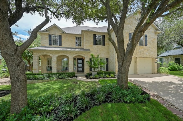 4004 Callabero Cv, Round Rock, TX 78681 - view of front of house with stone siding, driveway, an attached garage, a porch, and a front lawn