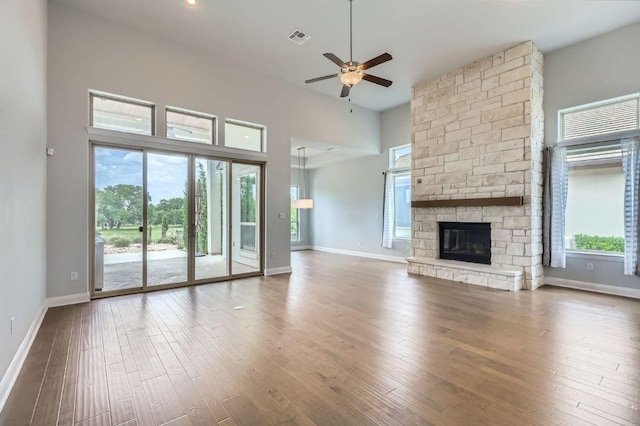 321 Cimarron Hills Trl E, Georgetown, TX 78628 - unfurnished living room with a ceiling fan, wood finished floors, a fireplace, and a high ceiling