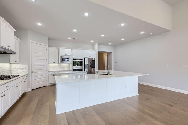 321 Cimarron Hills Trl E, Georgetown, TX 78628 - kitchen featuring stainless steel appliances, an island with sink, backsplash, white cabinets, and recessed lighting