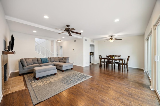 2704 San Pedro St Unit A16, Austin, TX 78705 - living room featuring a ceiling fan, a fireplace, stairs, wood finished floors, and recessed lighting
