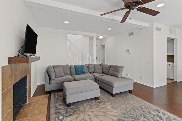 2704 San Pedro St Unit A16, Austin, TX 78705 - living area with stairs, a ceiling fan, recessed lighting, a tile fireplace, and wood finished floors