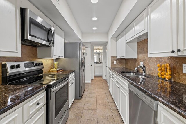 2704 San Pedro St Unit A16, Austin, TX 78705 - kitchen with appliances with stainless steel finishes, white cabinets, tasteful backsplash, dark stone countertops, and recessed lighting