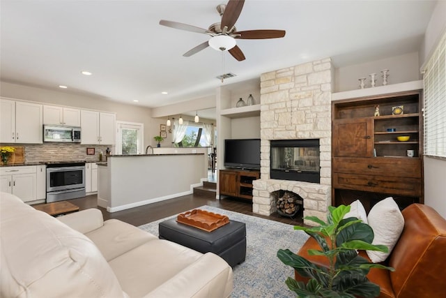 4500 Poteau Cir, Austin, TX 78734 - living area with a stone fireplace, dark wood-type flooring, a ceiling fan, and recessed lighting