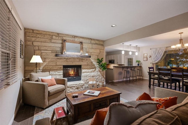 4500 Poteau Cir, Austin, TX 78734 - living area with wood finished floors, a stone fireplace, and a chandelier