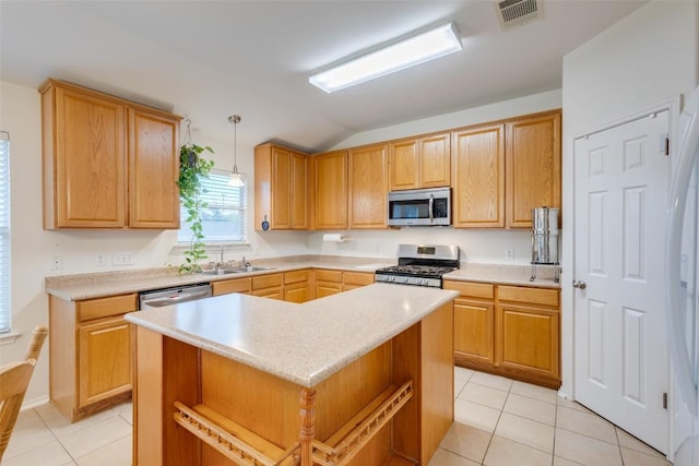 1312 Kothman Dr, Hutto, TX 78634 - kitchen featuring appliances with stainless steel finishes, light tile patterned floors, light countertops, lofted ceiling, and pendant lighting