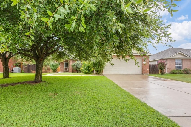 1312 Kothman Dr, Hutto, TX 78634 - view of property hidden behind natural elements with brick siding, concrete driveway, and an attached garage