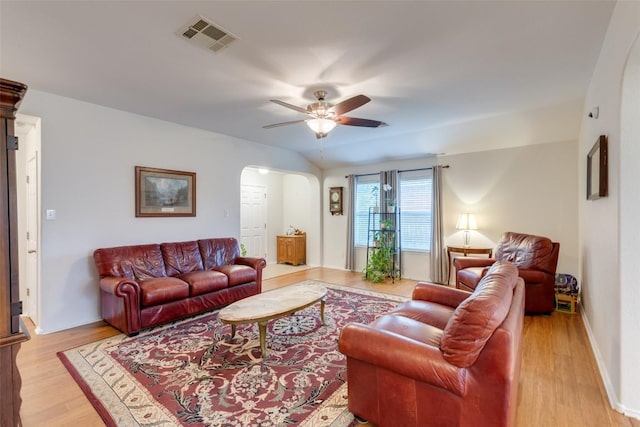 1312 Kothman Dr, Hutto, TX 78634 - living room featuring arched walkways, a ceiling fan, and light wood-style flooring