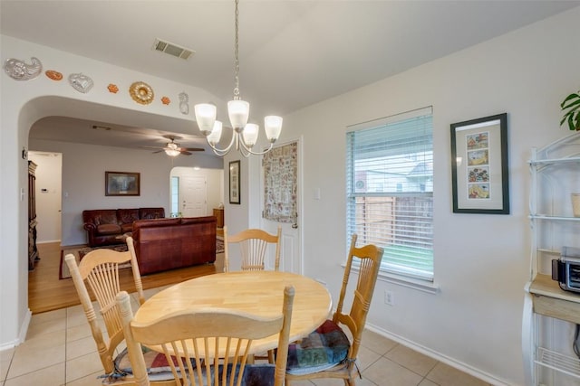 1312 Kothman Dr, Hutto, TX 78634 - dining space with light tile patterned floors, a chandelier, a ceiling fan, and arched walkways