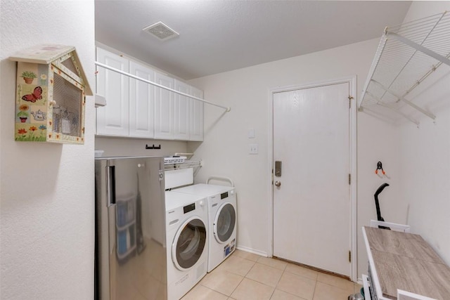 1312 Kothman Dr, Hutto, TX 78634 - laundry area featuring washing machine and dryer, light tile patterned floors, and cabinet space