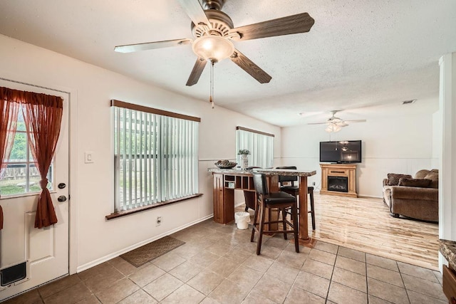 914 Hermitage Dr, Austin, TX 78753 - tiled dining room featuring ceiling fan and a fireplace