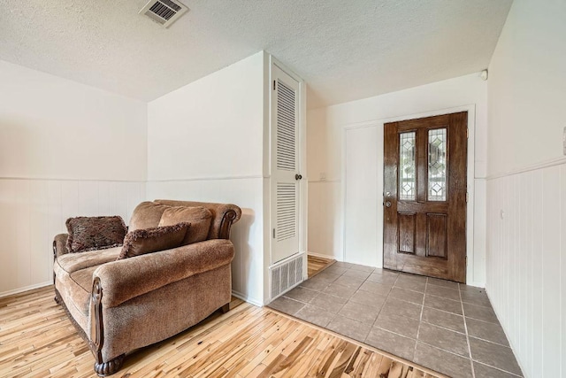 914 Hermitage Dr, Austin, TX 78753 - entrance foyer with a textured ceiling, wainscoting, and wood finished floors