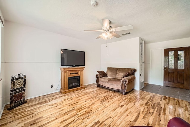 914 Hermitage Dr, Austin, TX 78753 - living room with hardwood / wood-style floors, ceiling fan, a textured ceiling, and a glass covered fireplace