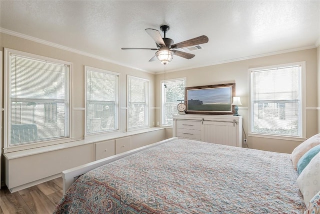 500 N Main St N, Burnet, TX 78611 - bedroom featuring wood finished floors, ornamental molding, a textured ceiling, and a ceiling fan
