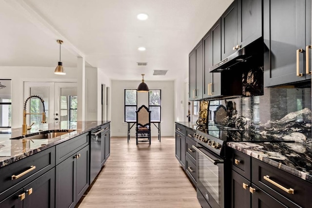 8401 Persimmon Grv, Austin, TX 78737 - kitchen with appliances with stainless steel finishes, dark stone countertops, light wood-type flooring, decorative light fixtures, and recessed lighting