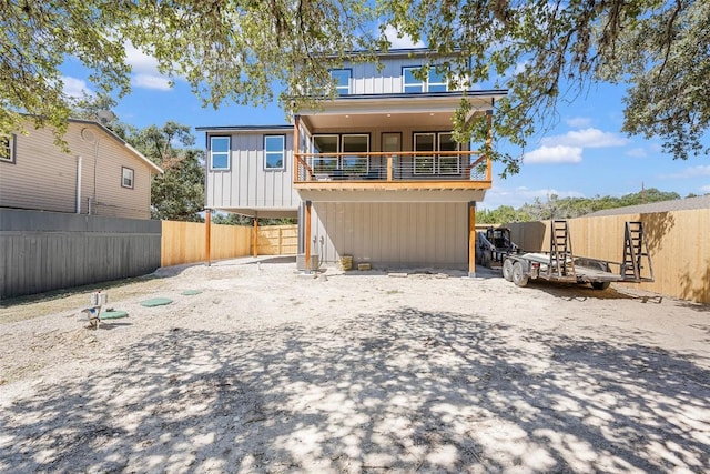 1156 Timberlane Dr, Canyon Lake, TX 78133 - rear view of property featuring a balcony, board and batten siding, and a fenced backyard
