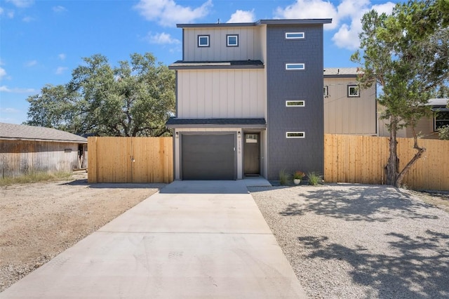 1156 Timberlane Dr, Canyon Lake, TX 78133 - view of front of home featuring concrete driveway, a gate, an attached garage, and board and batten siding