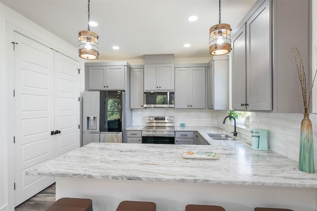 1156 Timberlane Dr, Canyon Lake, TX 78133 - kitchen featuring stainless steel appliances, gray cabinetry, a peninsula, tasteful backsplash, and light stone counters