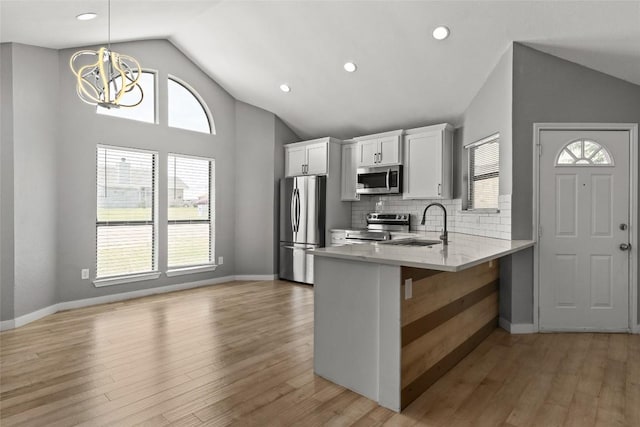109 Campfire Cir, Copperas Cove, TX 76522 - kitchen featuring appliances with stainless steel finishes, lofted ceiling, a chandelier, a peninsula, and white cabinets