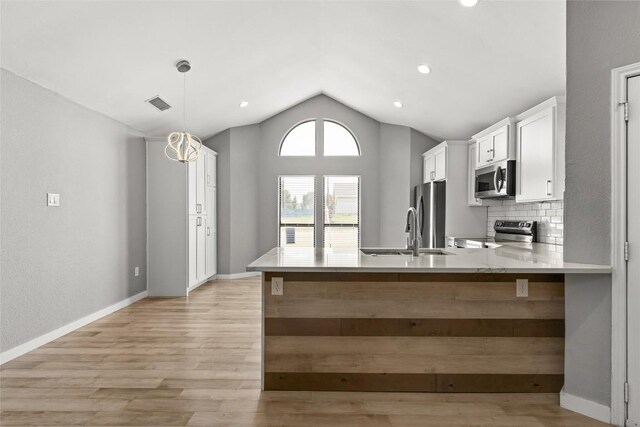 109 Campfire Cir, Copperas Cove, TX 76522 - kitchen with appliances with stainless steel finishes, vaulted ceiling, light wood-style flooring, white cabinetry, and a peninsula